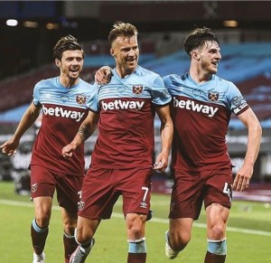 Aaron Cresswell (l) and Declan Rice (r) celebrate the winner together with goalscorer Andriy Yarmolenko (m)